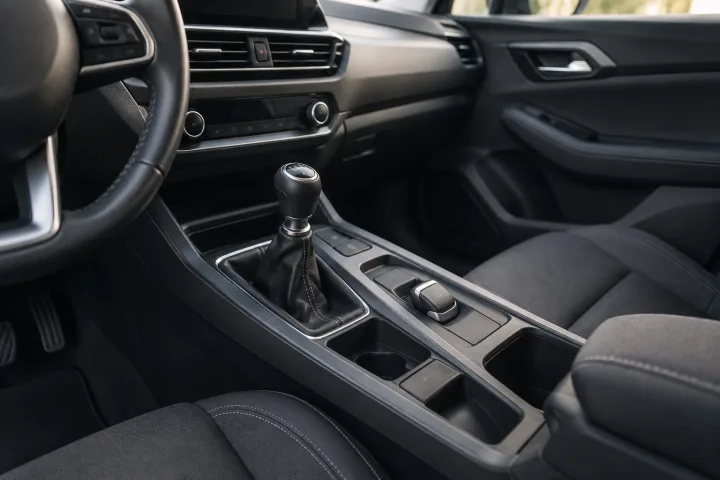Consola de un coche usado con una palanca de freno y un interruptor eléctrico representados como alternativas.